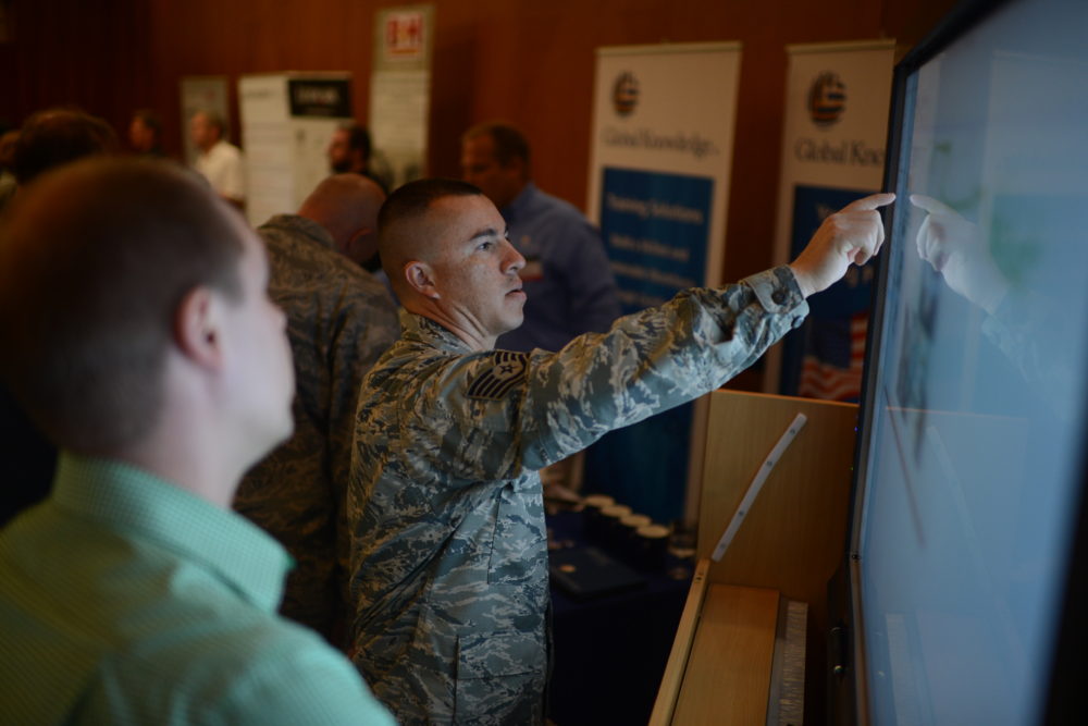 U.S. Air Force Tech. Sgt. Reinhard Valleau, a 52nd Civil Engineer Squadron operations administrator from Orlando, Fla., interacts with a smart board at the 2014 Spangdahlem Technology Expo at Club Eifel, July 30, 2014. National Conference Services Inc. put on the event to allow military members to collaborate with their industry counterparts and discuss future expectations of technology and equipment. (U.S. Air Force photo by Senior Airman Gustavo Castillo/Released)
